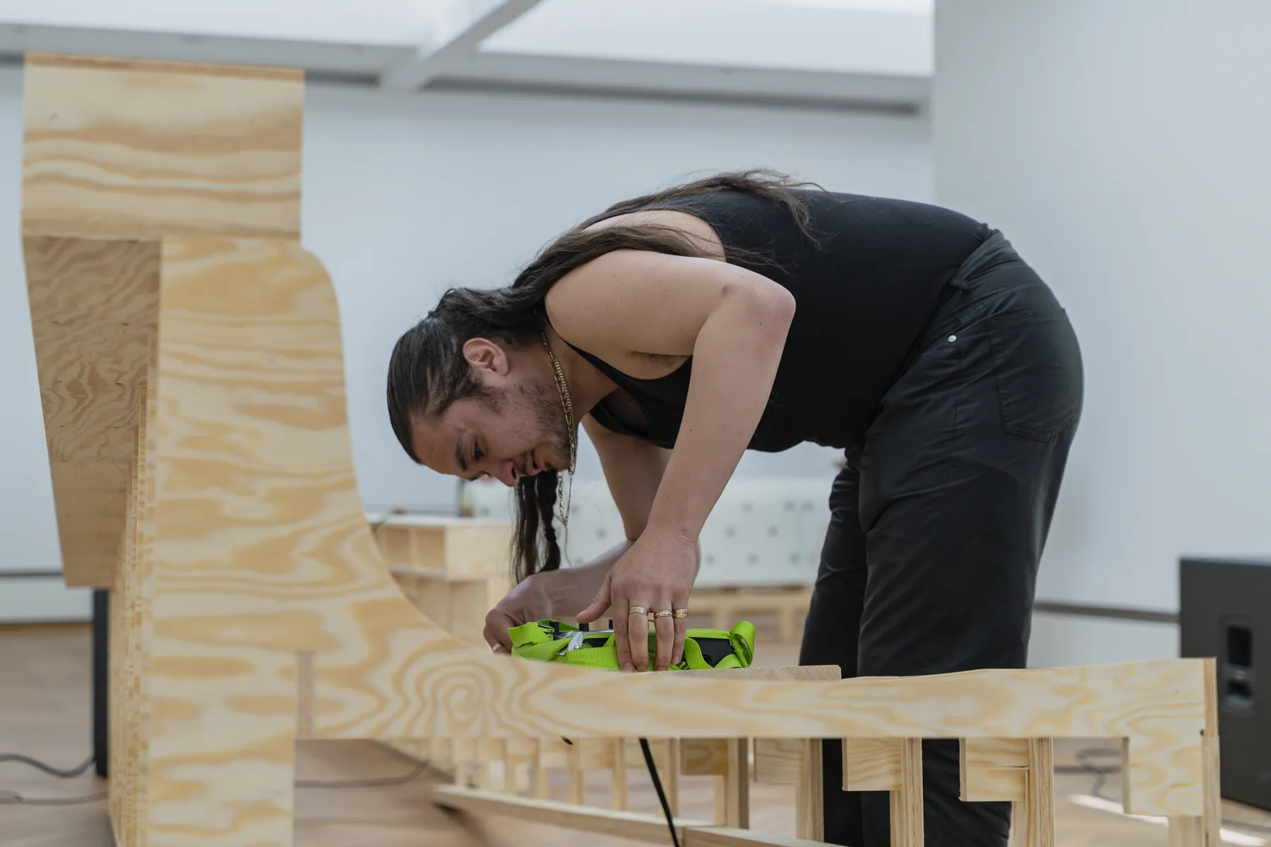 Visitors engaging with the installation, examining the wooden structure and audio equipment in the gallery at Trust Trust, Lübeck, 2025.